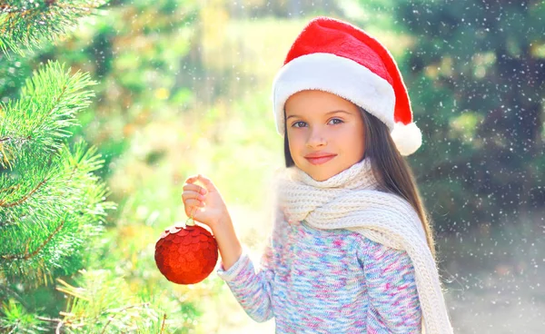 Christmas smiling child little girl in santa red hat with ball n — Stock Photo, Image