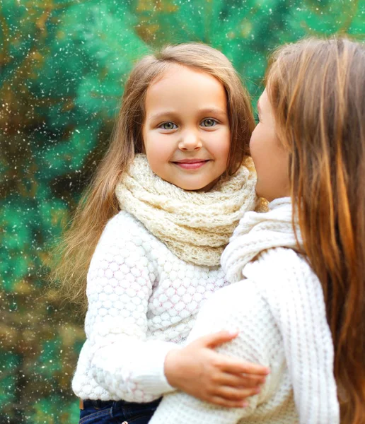 Bonne petite fille enfant embrassant mère en journée d'hiver sur l'arbre — Photo