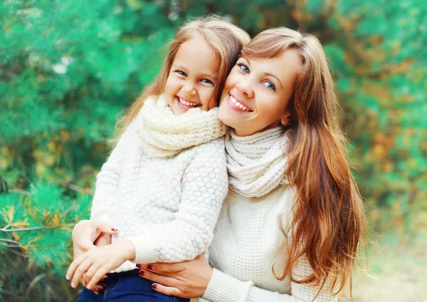 Happy smiling little girl child and mother in winter day over tr — Stock Photo, Image