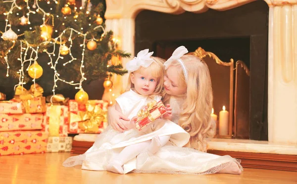 Crianças meninas com caixas de presente perto de árvore de natal e fi — Fotografia de Stock