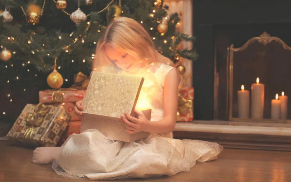 Happy child opens the magic box gift with light in dark over chr — Stock Photo, Image