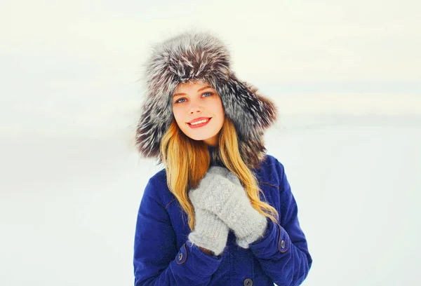 Winter fashion portrait happy smiling woman wearing a fur hat ov — Stock Photo, Image