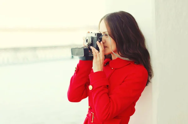 Молодая женщина фотограф фотографирует на винтажную камеру в — стоковое фото
