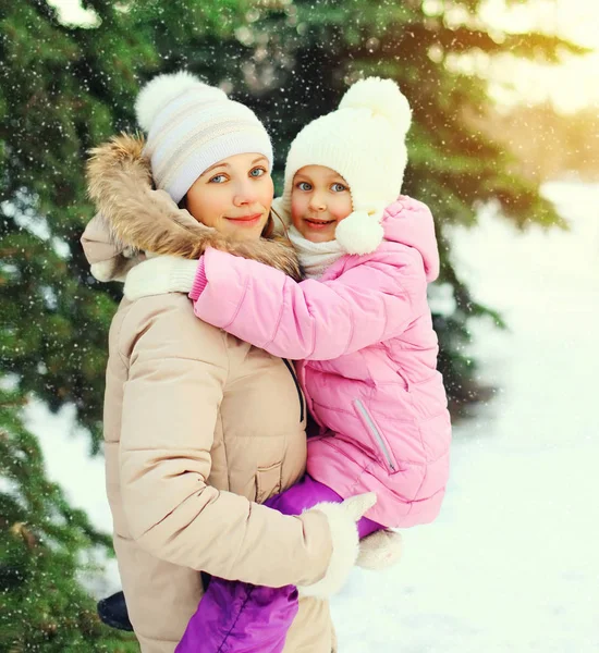 Invierno feliz madre e hijo sobre el árbol de Navidad y los copos de nieve —  Fotos de Stock