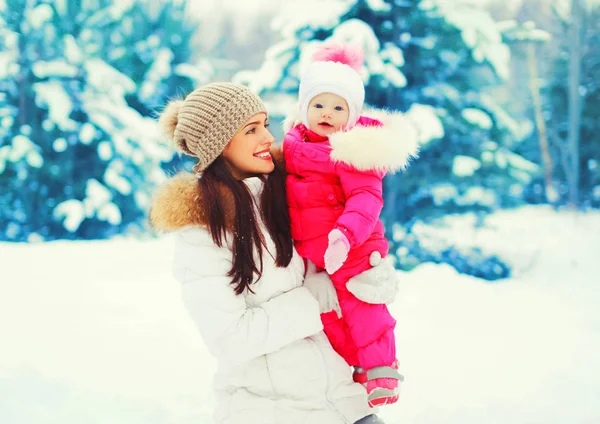 Winter portret gelukkig lachend moeder met baby op haar handen over — Stockfoto