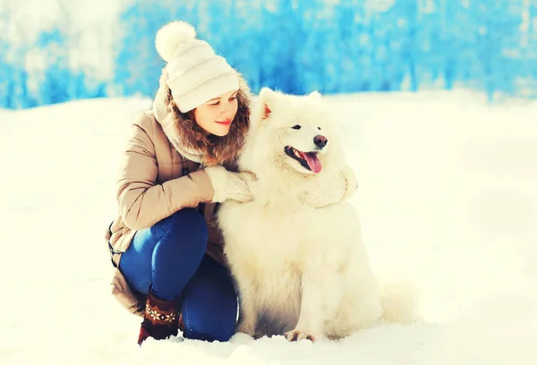 Woman owner hugging white Samoyed dog in winter park — Stock Photo, Image