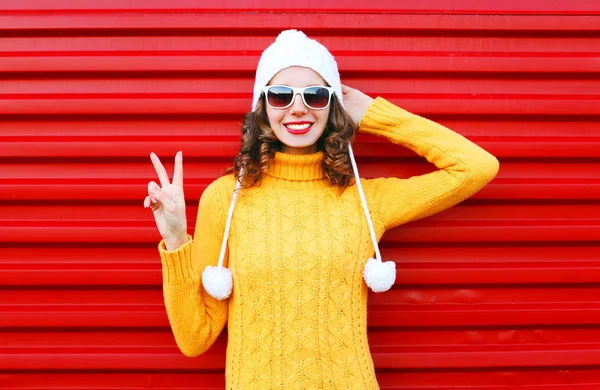 Модная улыбающаяся молодая женщина в цветной вязаной желтой поте — стоковое фото