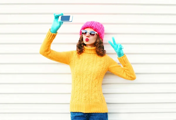 Модная молодая женщина фотографирует автопортрет на смартфон — стоковое фото