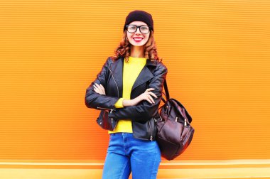 Çanta giyen bir siyah şapka, rock ceket ile gülümseyen kadın moda 