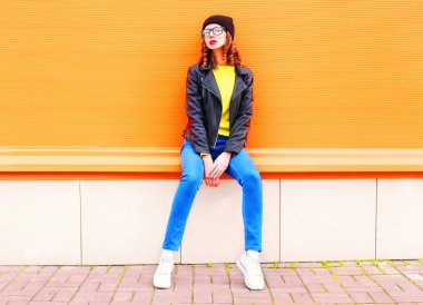 Moda kadın modeli siyah şapka ve rock ceket üzerinde turuncu col