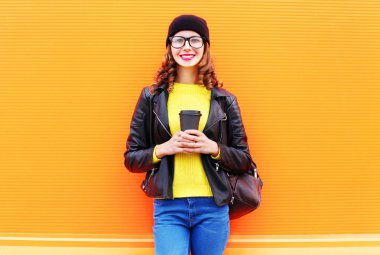 Kahve Kupası giyen ile genç gülümseyen güzel genç kadın moda