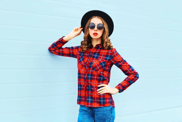 Mode jeune femme modèle portant un chapeau noir, chemise à carreaux rouges — Photo