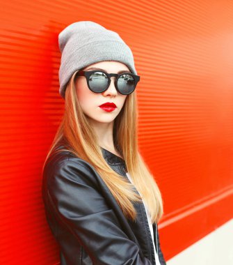 Güneş gözlüğü, şapka kırmızı backgr üzerinde giyen kadın moda portre