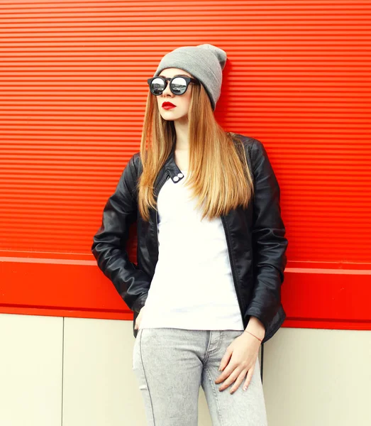 Moda mulher modelo vestindo um óculos de sol, chapéu sobre backgroun vermelho — Fotografia de Stock