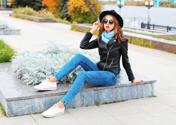 Moda joven posando en chaqueta de roca negro, sombrero a la par de la ciudad —  Fotos de Stock