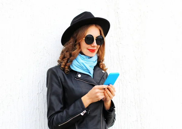 Мода молодая женщина, использующая смартфон в черной роковой куртке — стоковое фото