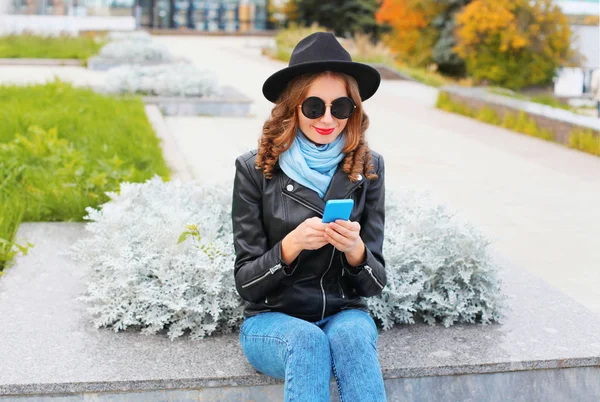 Moda joven mujer usando teléfono inteligente con chaqueta de roca negro , — Foto de Stock