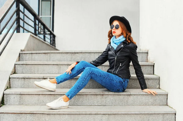 Moda mujer joven con chaqueta de roca negro, sombrero posando en cit — Foto de Stock