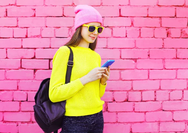 แฟชั่นสาวสวยเจ๋งใช้สมาร์ทโฟนเหนือสีชมพูสีสัน bac — ภาพถ่ายสต็อก