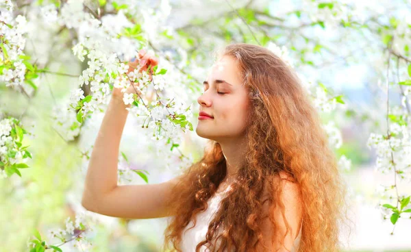 Hermosa joven mujer disfruta del olor flores de primavera sobre el jardín ba — Foto de Stock