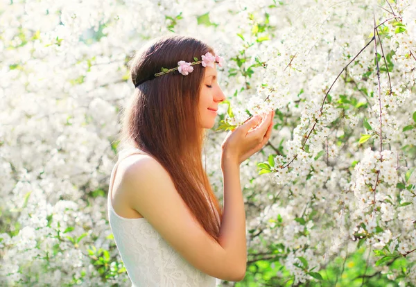 Belle femme appréciant l'odeur des fleurs de printemps sur la floraison gar — Photo