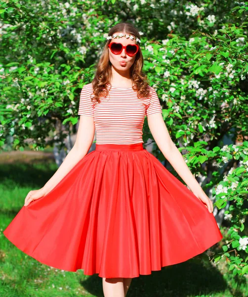 Fashion young woman in red skirt and heart shape sunglasses with — Stock Photo, Image