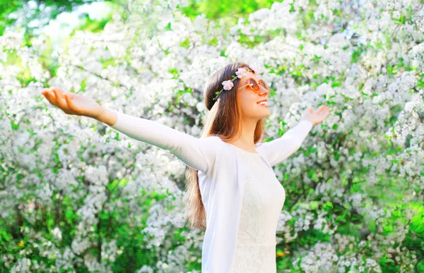 Feliz joven mujer disfrutando de la primavera sobre el jardín floreciente de nuevo — Foto de Stock