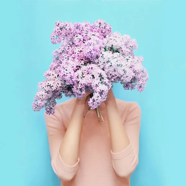 Mulher escondendo cabeça buquê lilás flores sobre colorido azul backg — Fotografia de Stock