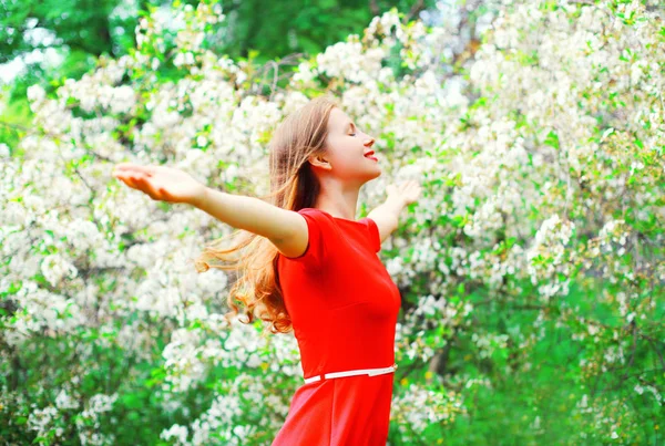 Ευτυχισμένη γυναίκα απολαμβάνει μυρωδιά στον κήπο την άνοιξη ανθοφορία — Φωτογραφία Αρχείου