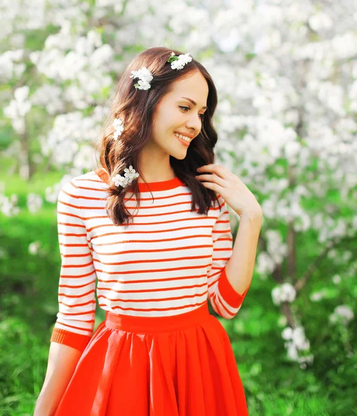 Portret gelukkig lachende vrouw met bloemblaadjes in het haar bij Lente f — Stockfoto