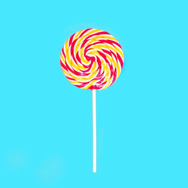 Colorido caramelo lollipop en palo sobre fondo azul vista superior — Foto de Stock