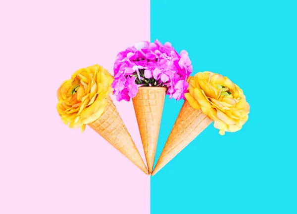 Three ice cream cone with colorful flowers over pink blue backgr — Stock Photo, Image