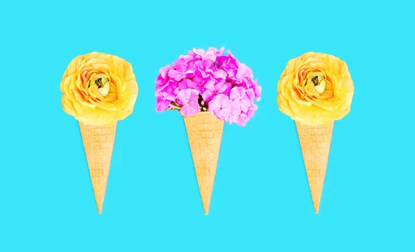 三个蛋卷冰淇淋与花在蓝色的彩色背景 — 图库照片
