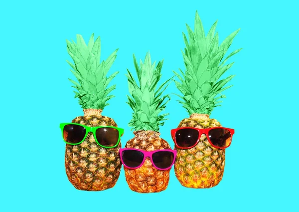 Три ананаса с солнцезащитными очками на синем фоне, красочная Анна — стоковое фото