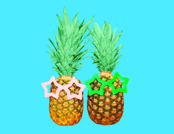 Due ananas con occhiali da sole su sfondo blu, anana colorata — Foto Stock