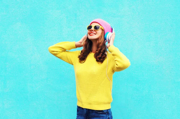 Menina da moda ouvindo música em fones de ouvido vestindo um colorido — Fotografia de Stock