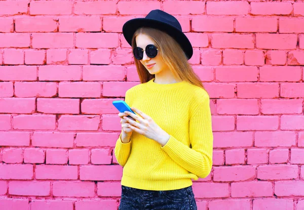 Üzerinde renkli pembe bri Smartphone kullanarak oldukça serin kız moda — Stok fotoğraf
