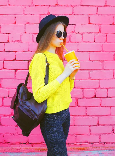 Mujer de moda con taza de jugo de frutas sobre coloridos ladrillos rosados — Foto de Stock