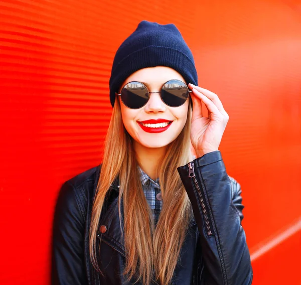 Retrato de moda rubia sonriente mujer en rock estilo negro sobre rojo —  Fotos de Stock