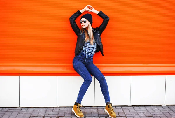 Moda mulher loira bonita posando em estilo rock preto em um vermelho — Fotografia de Stock