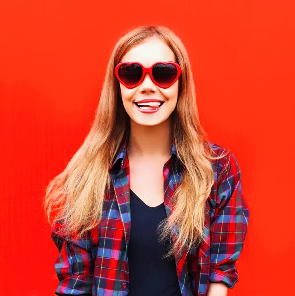 Porträtt lycklig ganska ung kvinna i röda solglasögon form av hea — Stockfoto