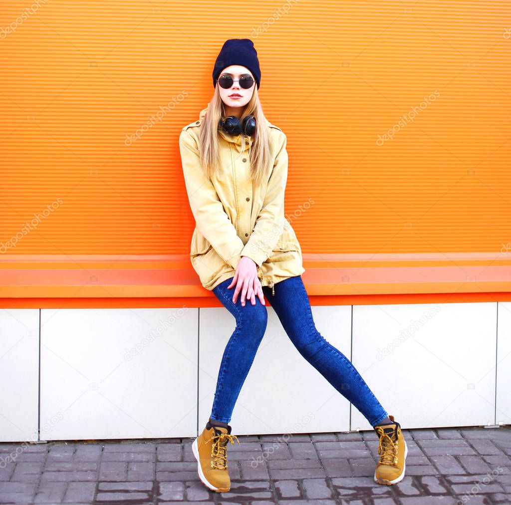 Fashion pretty blonde woman on a orange colorful background in c