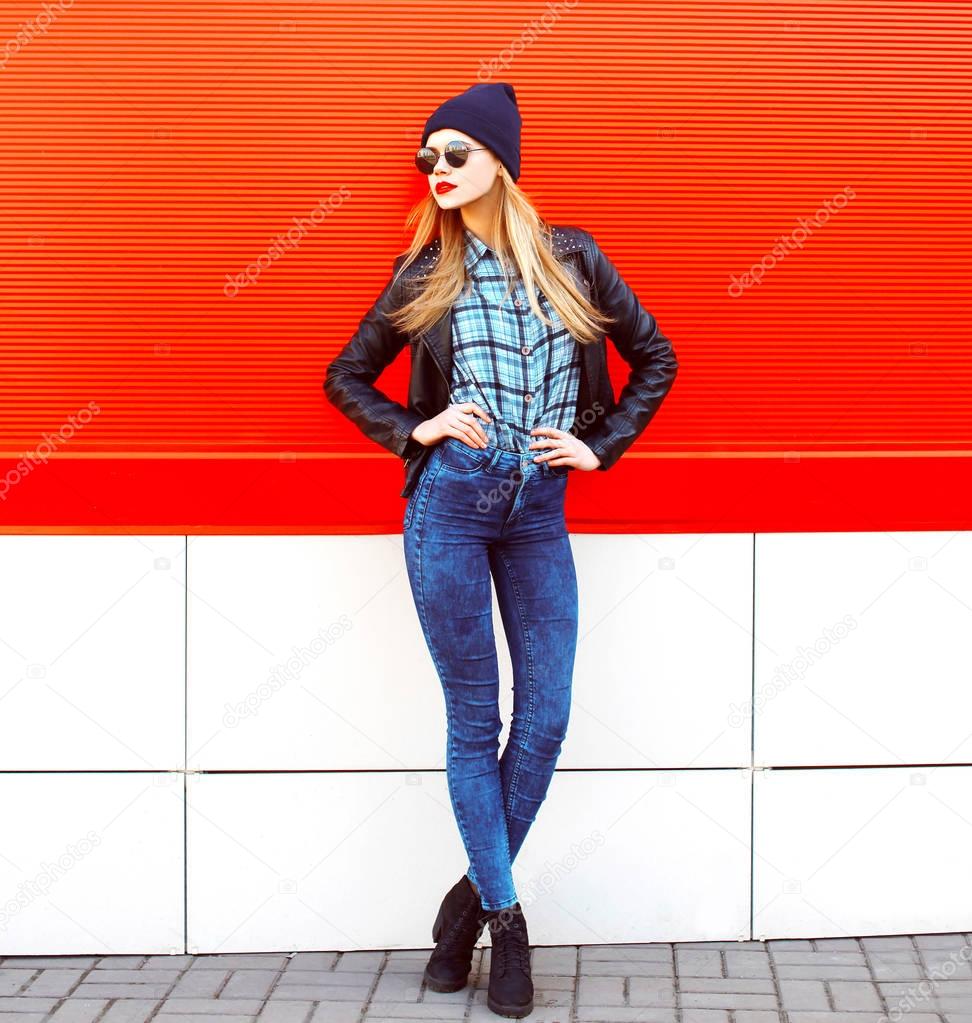 Fashion pretty blonde woman posing in rock black style over red 