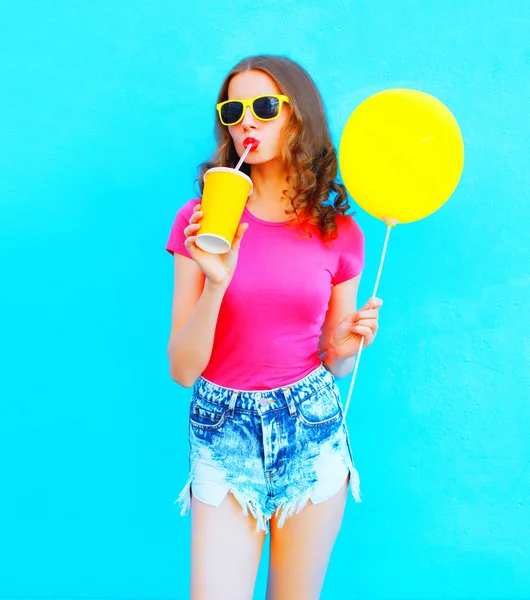 Moda jovem mulher vestindo uma camiseta, calções jeans bebe frutas — Fotografia de Stock
