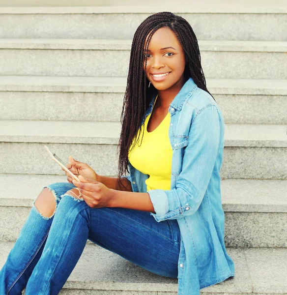 Schöne junge lächelnde Afrikanerin mit Tablet-PC — Stockfoto