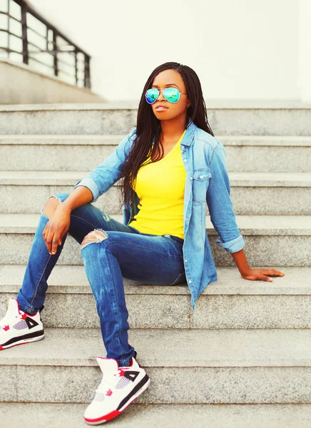 Mode ung afrikansk kvinna som bär en solglasögon och jeans skjorta — Stockfoto
