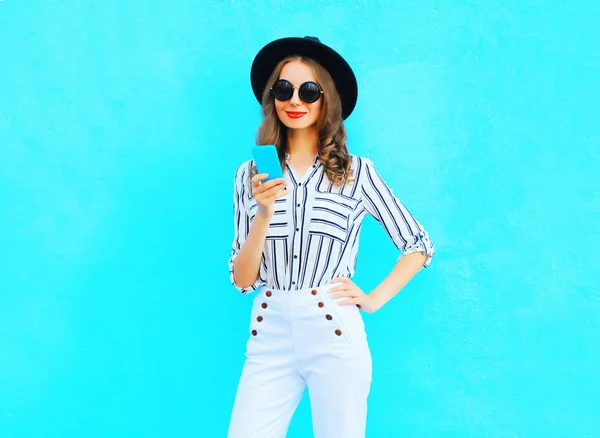 Fashion pretty young woman is using a smartphone wearing a black — Stock Photo, Image