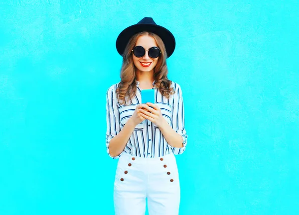 Moda joven sonriente mujer está utilizando un teléfono inteligente con un blac —  Fotos de Stock