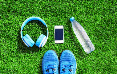 Bir kulaklık mavi ve beyaz smartphone ile spor spor ayakkabı ayakkabı