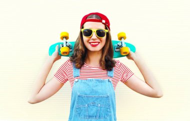 Beyaz arka plan üzerinde kaykay ile gülümseyen kız moda serin